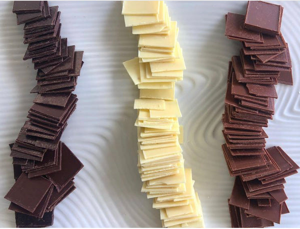 samples of craft dark, white and milk chocolate on a white plate