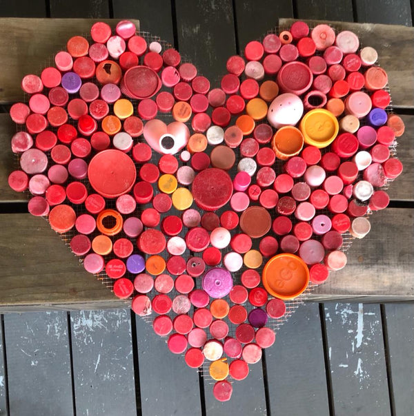 red heart made from bottle tops found on the beach