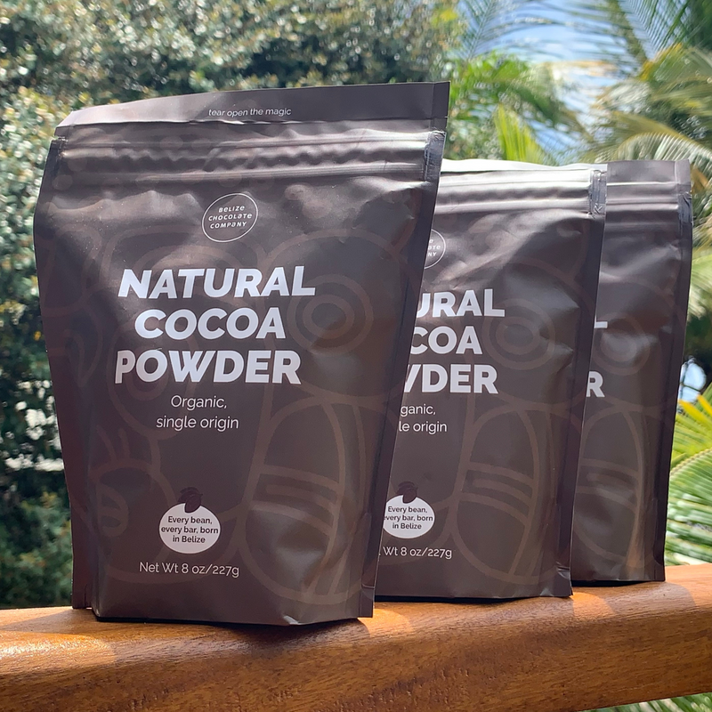 three brown standup pouches containing natural cocoa powder made by Belize Chocolate Company